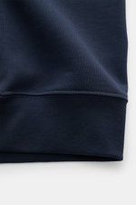 Detailaufnahme der Belstaff Sweatjacke 'Curator' navy aus reiner Supima-Baumwolle, Blick auf Rippbündchen mit geschmeidigem Griff, Slim Fit, robustem Reißverschluss, Kapuze mit Tunnelzug, Taschen in der Seitennaht und tonalem BELSTAFF-Weblabel.