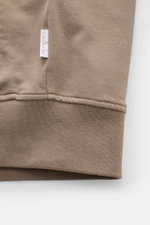 Nahaufnahme der 04651/ A trip in a bag Sweatjacke 'IF Track' taupe, Detailansicht des elastischen Rippbündchens und Baumwoll-Jersey mit Weblabel.