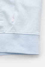 Nahaufnahme der pastellblauen 04651/ A trip in a bag Sweatjacke 'IF Track' mit elastischem Rippbündchen und kleinem Weblabel, Detailansicht aus seitlicher Perspektive, gefertigt aus super softem Baumwoll-Jersey mit elastischer Qualität.
