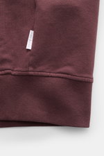 Nahaufnahme der elastischen Rippbündchen und des weißen Weblabels der 04651/ A trip in a bag Sweatjacke 'IF Track' bordeaux aus Baumwoll-Jersey.