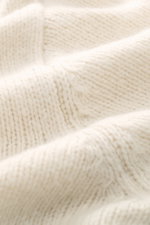 Detailaufnahme des groben Strickbilds von 04651/ A trip in a bag Cardigan 'Hunter' creme, Mix aus Merinowolle und Microfaser, weicher Griff, Rippbündchen sichtbar.