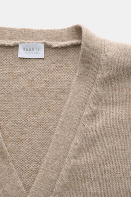 Bild zeigt den Ausschnitt von 04651/ A trip in a bag Cardigan 'Hunter' taupe meliert, fotografiert von oben, mit V-Ausschnitt, grobem Strickbild, weichem Griff, Regular Fit, Vier-Knopf-Leiste, aufgesetzten Fronttaschen und komfortablen Rippbündchen, Mix a