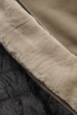 Close-up, top-down view of the taupe Moose Knuckles Sweat jacket 'Classic Bunny' showing the soft faux fur lining and branded quilted interior.

<p>Perfect for cold days: With lightweight padding and a hood with detachable faux fur lining, you will be wel