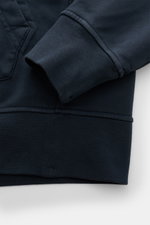Stone Island Kapuzenpullover navy, Detailaufnahme von Ärmel und Kängurutasche, Sweat aus reiner Baumwolle, weicher Griff, garment dyed, Regular Fit, markante Overlock-Nähte, praktische Kapuze mit Tunnelzug, typisches Kompass-Badge am Ärmel, komfortable Ri