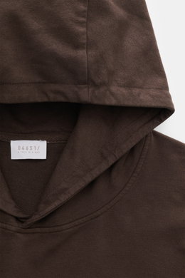 Detailaufnahme aus Frontperspektive des dunkelbraunen 04651/ A trip in a bag Kapuzenpullover 'IF Hoodie' aus reiner Baumwolle, elastisch, sehr weich, Regular Fit mit praktischer Kapuze, kleinem Weblabel in der Seitennaht und komfortablen Rippbündchen.