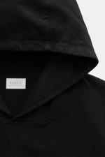 Nahaufnahme des schwarzen Kapuzenbereichs aus schräger Perspektive des 04651/ A trip in a bag Kapuzenpullover 'IF Hoodie' schwarz, reine Baumwolle, elastische Qualität, sehr weicher Griff, Regular Fit, praktische Kapuze, kleines Weblabel in der Seitennaht