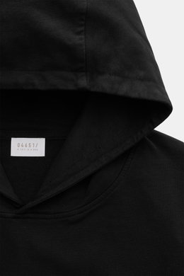 Nahaufnahme des schwarzen Kapuzenbereichs aus schräger Perspektive des 04651/ A trip in a bag Kapuzenpullover 'IF Hoodie' schwarz, reine Baumwolle, elastische Qualität, sehr weicher Griff, Regular Fit, praktische Kapuze, kleines Weblabel in der Seitennaht