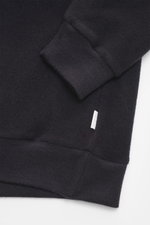 Nahaufnahme des Ärmels und Saums des 04651/ A trip in a bag Kapuzenpullover 'CW Hoodie' navy, fotografiert von oben, Mix aus Wolle und Baumwolle, weicher Griff, Regular Fit, praktische Kapuze, kleines Weblabel in der Seitennaht, komfortable Rippbündchen.