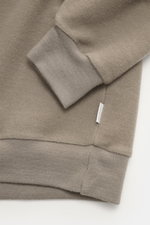 Nahaufnahme des Ärmelbündchens und Saums vom 04651/ A trip in a bag Kapuzenpullover 'CW Hoodie' taupe, Regular Fit, Mix aus Wolle und Baumwolle, weicher Griff, praktische Kapuze, kleines Weblabel in der Seitennaht, komfortable Rippbündchen.