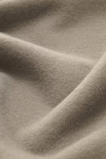 Nahaufnahme der Stoffstruktur des 04651/ A trip in a bag Kapuzenpullover 'CW Hoodie' taupe, Mix aus Wolle und Baumwolle, weicher Griff, Regular Fit, praktische Kapuze, kleines Weblabel in der Seitennaht, komfortable Rippbündchen.