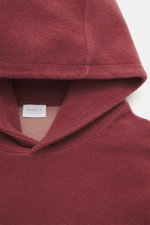 Nahaufnahme aus schräger Frontalperspektive des Kapuzenbereichs vom 04651/ A trip in a bag Kapuzenpullover 'CW Hoodie' rotbraun, Mix aus Wolle und Baumwolle, weicher Griff, Regular Fit, praktische Kapuze, kleines Weblabel in der Seitennaht, komfortable Ri