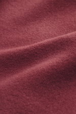 Nahaufnahme der rotbraunen Stoffstruktur des 04651/ A trip in a bag Kapuzenpullover 'CW Hoodie' mit weichem Griff, Wolle-Baumwolle-Mix, Regular Fit, Kapuze, Weblabel und Rippbündchen.
