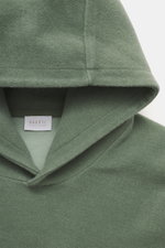 Nahaufnahme des Kapuzenbereichs von 04651/ A trip in a bag Kapuzenpullover 'CW Hoodie' salbei, Mix aus Wolle und Baumwolle, weicher Griff, Regular Fit, praktische Kapuze, kleines Weblabel in der Seitennaht, komfortable Rippbündchen, fotografiert von oben.