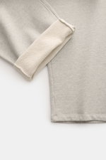 Ami Paris Sweathose 'Quota' grau meliert close-up from the side showing the soft, elastic cotton fabric with a folded cuff revealing the inner texture, highlighting the regular fit and clean silhouette. 

<p>Komfort trifft auf Pariser Lässigkeit: Die 'Quo