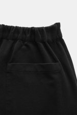 Detailaufnahme der schwarzen 04651/ A trip in a bag Jogpants 'If' aus Baumwoll-Jersey, Fokus auf Bund und Gesäßtasche, von hinten.