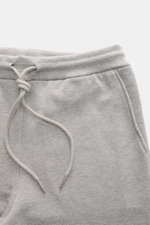 Thom Browne Sweathose grau meliert aus reiner Baumwolle, Slim Fit, elastischer Bund mit Tunnelzug, Perspektive von oben auf Bund und Taschen.