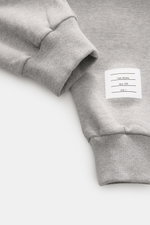 Nahaufnahme der Thom Browne Sweathose grau meliert aus reiner Baumwolle, Perspektive zeigt Bündchen und Markenlabel, weicher Griff, Slim Fit, elastischer Bund mit Tunnelzug und Rippbündchen.