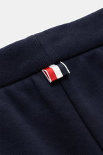 Nahaufnahme der Thom Browne Sweathose weiß/navy am elastischen Bund mit Tunnelzug, markentypischem Streifen-Detail und weichem Baumwollstoff.