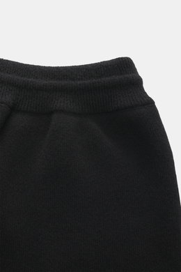 Close-up front view of Ami Paris Merino jogpants black, showing high elastic waistband with drawstring, pure merino wool, soft touch, loose fit, leather logo detail, comfortable ribbed cuffs, and side pockets.