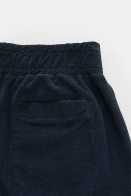 Close-up rear view of 04651/ A trip in a bag 'Terry' shorts navy, showcasing elastic waistband, back hip pocket, and soft terrycloth texture.

<p>With the model 'Terry' 04651/ A TRIP IN A BAG presents a comfortable pair of shorts in wonderfully soft terry