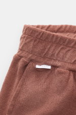 Nahaufnahme der rostbraunen 04651/ A trip in a bag Frottee-Shorts "Terry" aus weichem Baumwoll-Frottee, Perspektive auf Bund und Taschen.
