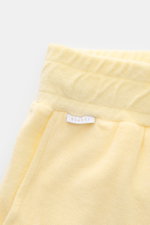 Nahaufnahme von 04651/ A trip in a bag Frottee-Shorts 'Terry' pastellgelb, weicher Baumwoll-Frottee, elastischer Bund mit Tunnelzug, Taschen, kleines Weblabel.