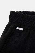 Schwarze 04651/ A trip in a bag Frottee-Shorts 'Terry' aus weichem Baumwoll-Frottee, elastichem Bund mit Tunnelzug, seitlich fotografiert.