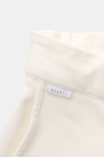 04651/ A trip in a bag Sweat-Shorts offwhite aus Baumwolle, elastischer Bund, weicher Griff, französische Taschen, Detailaufnahme vom Bund mit Label.