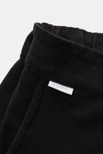 Schwarze 04651/ A trip in a bag Sweat-Shorts aus elastischer Baumwolle, Nahaufnahme seitlich oben mit elastischem Bund und kleinem Weblabel.