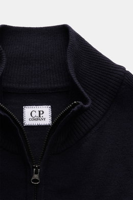 Nahaufnahme des C.P. Company Troyer navy aus weicher Schurwolle mit Troyer-Kragen, Reißverschluss und labeltypischem Linsen-Detail.