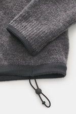 Stone Island Troyer 'Stellina' dunkelgrau meliert, Nahaufnahme von Ärmel und Bund, Mix aus Schurwolle und Microfaser, weicher Griff, Regular Fit, Troyer-Kragen, Rippbündchen, dezentes Stellina-Stitching.