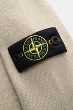 Close-up front view of the Stone Island Half-zip jumper 'Lambswool' taupe showcasing the signature black compass badge with green and yellow embroidery and embossed buttons on warm wool blend knitwear. 

<p>A stylish essential for the colder months: This 