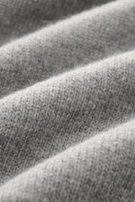 Stone Island Half-zip jumper 'Lambswool' grey melange close-up showing soft wool blend texture from a macro perspective.  
A stylish essential for the colder months: This timeless half-zip jumper by STONE ISLAND with zip and embossed buttons on the collar