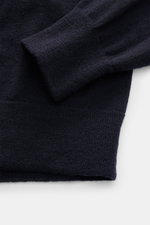 Close-up from above of the Stone Island Troyer black sleeve and hem showing fine knit pattern and soft texture.

<p>Comfort meets style: The STONE ISLAND quarter-zip jumper complements your autumn wardrobe with warming comfort and modern versatility.</p>
