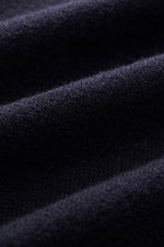 Close-up view of the fine knit pattern and soft touch fabric of the Stone Island Troyer black made from virgin wool and microfiber.