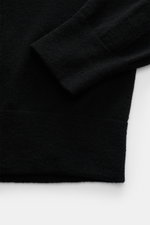 Close-up detail of the sleeve and hem of the Stone Island Troyer black jumper, photographed from above showing soft knit texture.

Description: <p>Comfort meets style: The STONE ISLAND quarter-zip jumper complements your autumn wardrobe with warming comfo