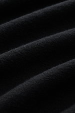 Close-up, angled view of Stone Island Troyer black showing fine knit pattern and soft texture of virgin wool and microfiber fabric. Comfort meets style: The STONE ISLAND quarter-zip jumper complements your autumn wardrobe with warming comfort and modern v