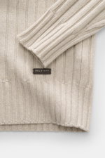 Close-up top-down view of Belstaff Troyer 'Lincoln' beige rib knit wool and cashmere sweater sleeve and hem with BELSTAFF label.

<p>The soft Troyer 'Lincoln' is made from wool with a smooth cashmere content and is part of the 'Phoenix' Capsule Collection