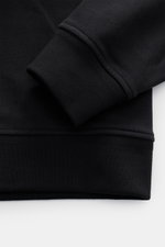 Close-up from the side of the cuff and hem of the Belstaff Sweat half-zip jumper 'Quarter Zip' black, showing sweat fabric made of cotton with a soft feel, slim fit, half-zip collar, BELSTAFF woven label on the chest, and flexible ribbed bands.