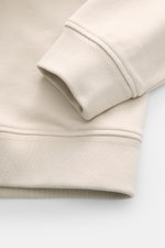 Close-up view of the cuff and hem of the Belstaff Sweat half-zip jumper 'Quarter Zip' beige, made of sweat fabric cotton with soft feel, slim fit, half-zip collar, BELSTAFF woven label on the chest, and flexible ribbed bands.