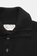 Close-up front view of Ami Paris Merino sweater black, showcasing troyer collar with 5-button placket, pure merino wool, soft feel, regular fit, back yoke with logo patch, and comfortable ribbed cuffs.