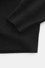 Ami Paris Merino sweater black shown from a close-up angle highlighting comfortable ribbed cuffs, pure merino wool, soft feel, regular fit, troyer collar with 5-button placket, and back yoke with logo patch.