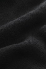 A close-up front view of Ami Paris Merino sweater black fabric showing pure merino wool, soft feel, regular fit, troyer collar with 5-button placket, back yoke with logo patch, and comfortable ribbed cuffs.