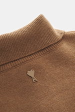 Ami Paris Merino Troyer hellbraun in Nahaufnahme von oben, reine Merinowolle, weicher Griff, Regular Fit, Troyer-Kragen mit 5-Knopf-Leiste, Rückenpasse mit Logo-Patch, komfortable Rippbündchen.