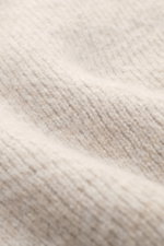 Nahaufnahme des beigen 04651/ A trip in a bag Troyer 'Shadow Norwegian' mit tonalem Norweger-Strickmuster, mittelfeinem, voluminösem Strickbild, weichem Griff, Slim Fit, Troyer-Kragen mit Reißverschluss und komfortablen Rippbündchen, fotografiert aus seit