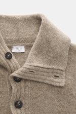 Nahaufnahme aus schräger Perspektive des 04651/ A trip in a bag Troyer 'Cloudy Wool' taupe meliert mit Troyer-Kragen, Knöpfen, Regular Fit, weichem Griff, mittelgrobem Strickbild, breiten Rippbündchen aus Schurwolle und Microfaser.