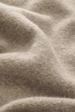 Nahaufnahme der Stoffstruktur von 04651/ A trip in a bag Troyer 'Cloudy Wool' taupe meliert, Mix aus Schurwolle und Microfaser, weicher Griff, mittelgrobes Strickbild.
