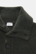 Nahaufnahme aus schräger Vogelperspektive des dunkelgrün melierten 04651/ A trip in a bag Troyer 'Cloudy Wool' mit Troyer-Kragen, Knöpfen, Regular Fit, breiten Rippbündchen, mittelgrobem Strickbild, weichem Griff, Mix aus Schurwolle und Microfaser.