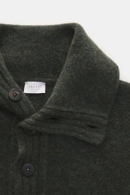 Nahaufnahme aus schräger Vogelperspektive des dunkelgrün melierten 04651/ A trip in a bag Troyer 'Cloudy Wool' mit Troyer-Kragen, Knöpfen, Regular Fit, breiten Rippbündchen, mittelgrobem Strickbild, weichem Griff, Mix aus Schurwolle und Microfaser.
