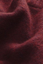 Nahaufnahme der Stoffstruktur in dunkelrot meliert, Detail des mittelgroben Strickbilds vom 04651/ A trip in a bag Troyer 'Cloudy Wool', Mix aus Schurwolle und Microfaser, weicher Griff.